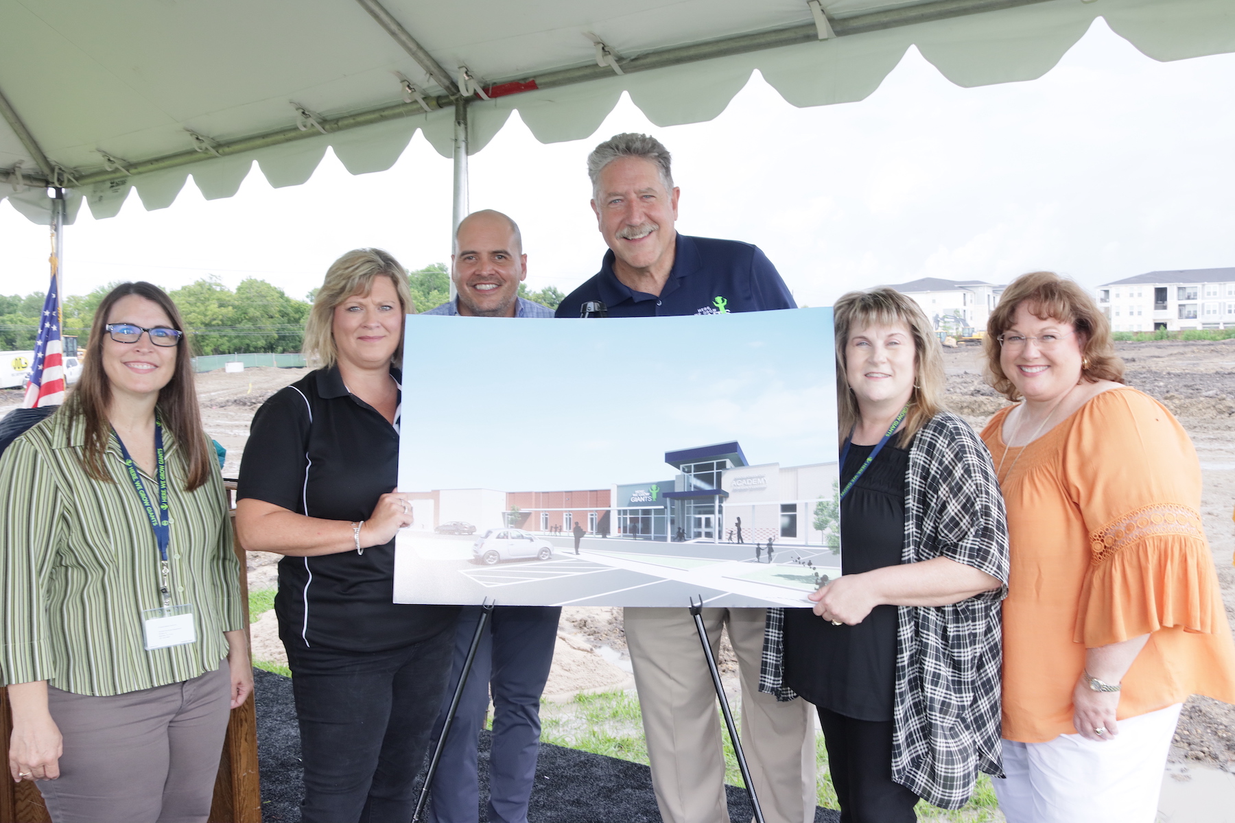 District leaders pose in front of Early Learning Academy rendering