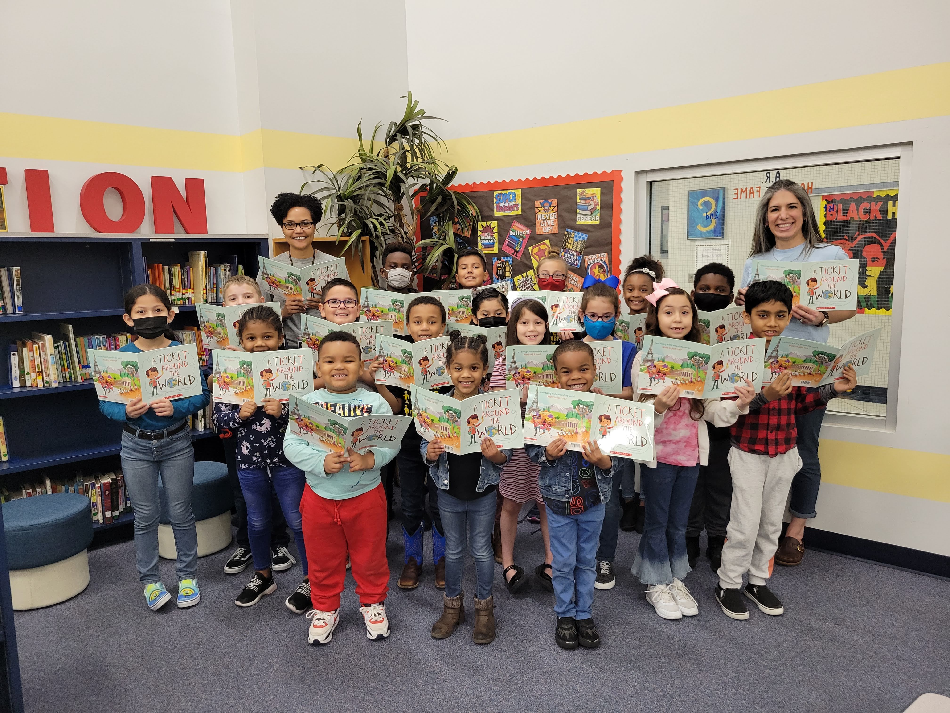 Students and librarian pose each holding a copy of the book A ticket around the world