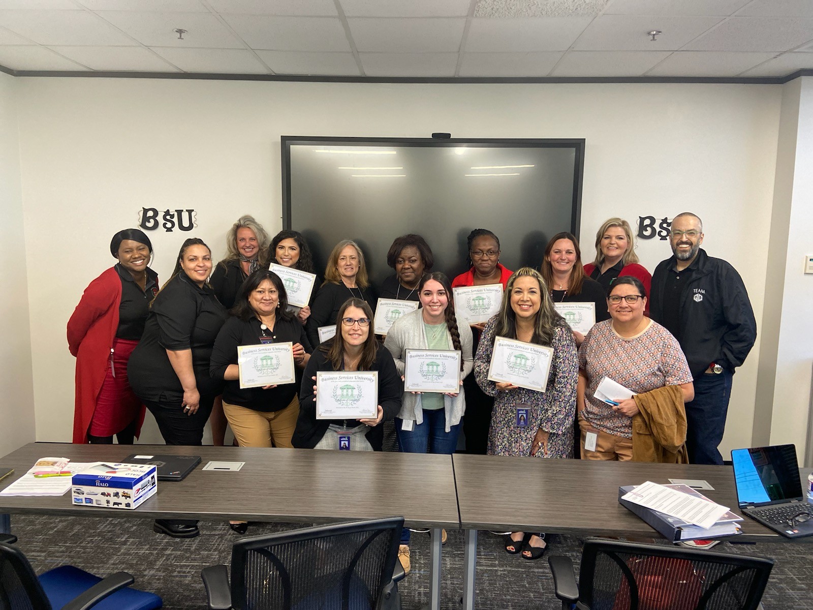 Members of the first graduating class of BUS pose proudly with their certificates