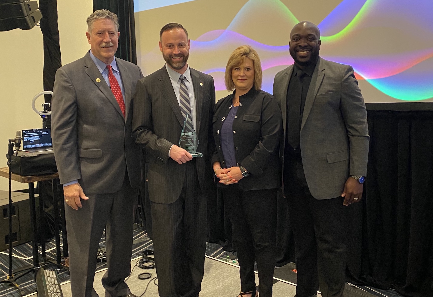 chief technology officer of the year matt flood stands with his award next to district leaders