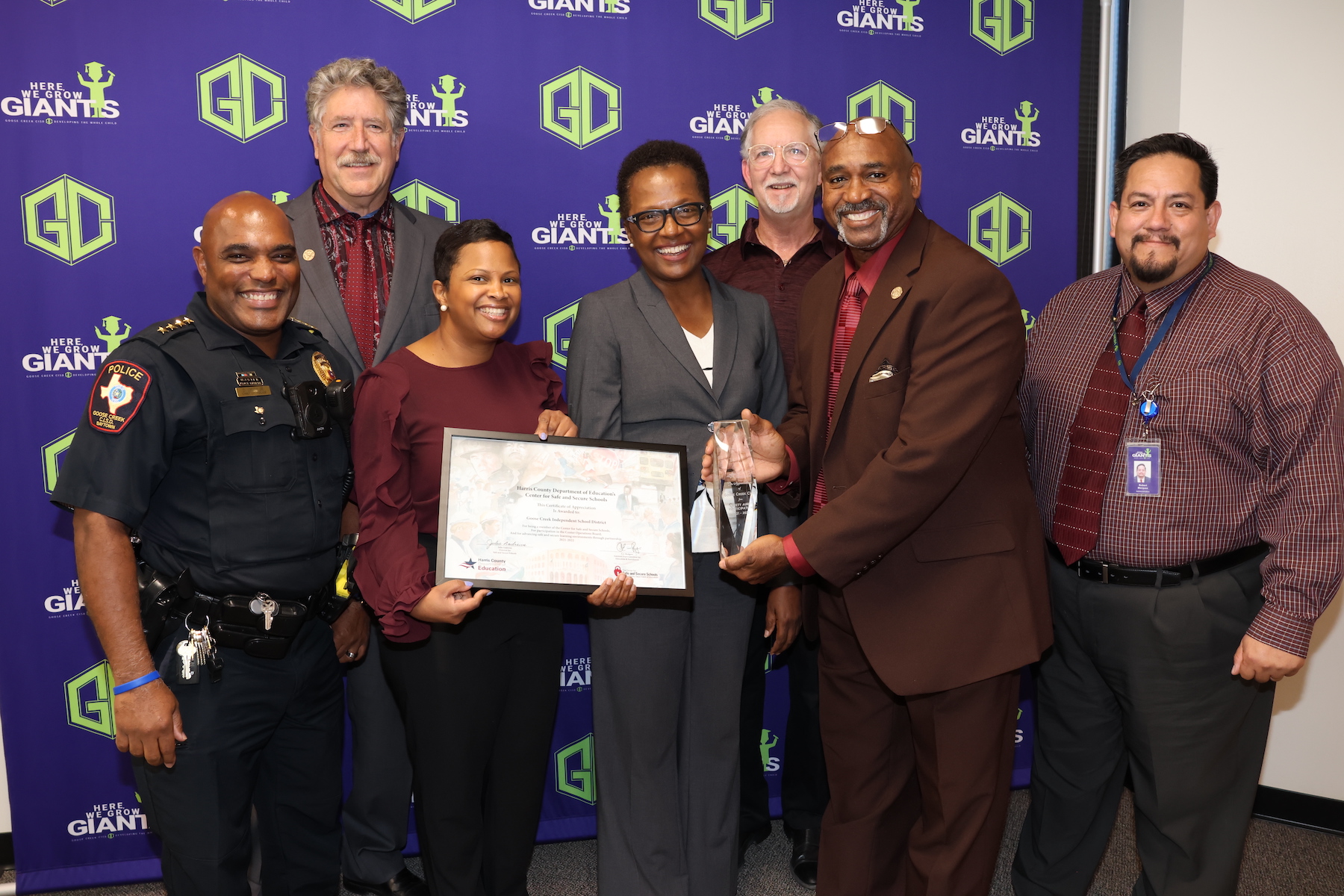 Chief davis and district administrators pose with HCDE Center employees