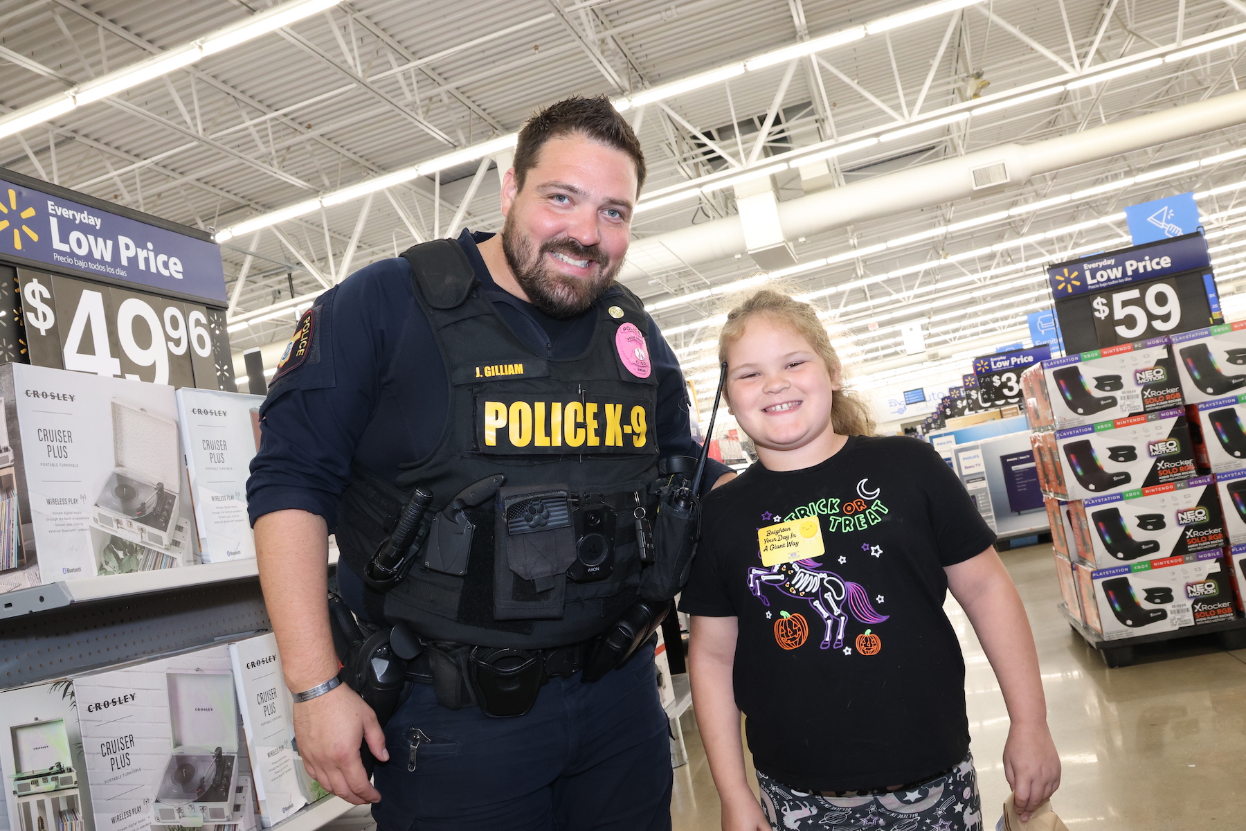 officer gilliam poses with student at walmart at the brighten your day event