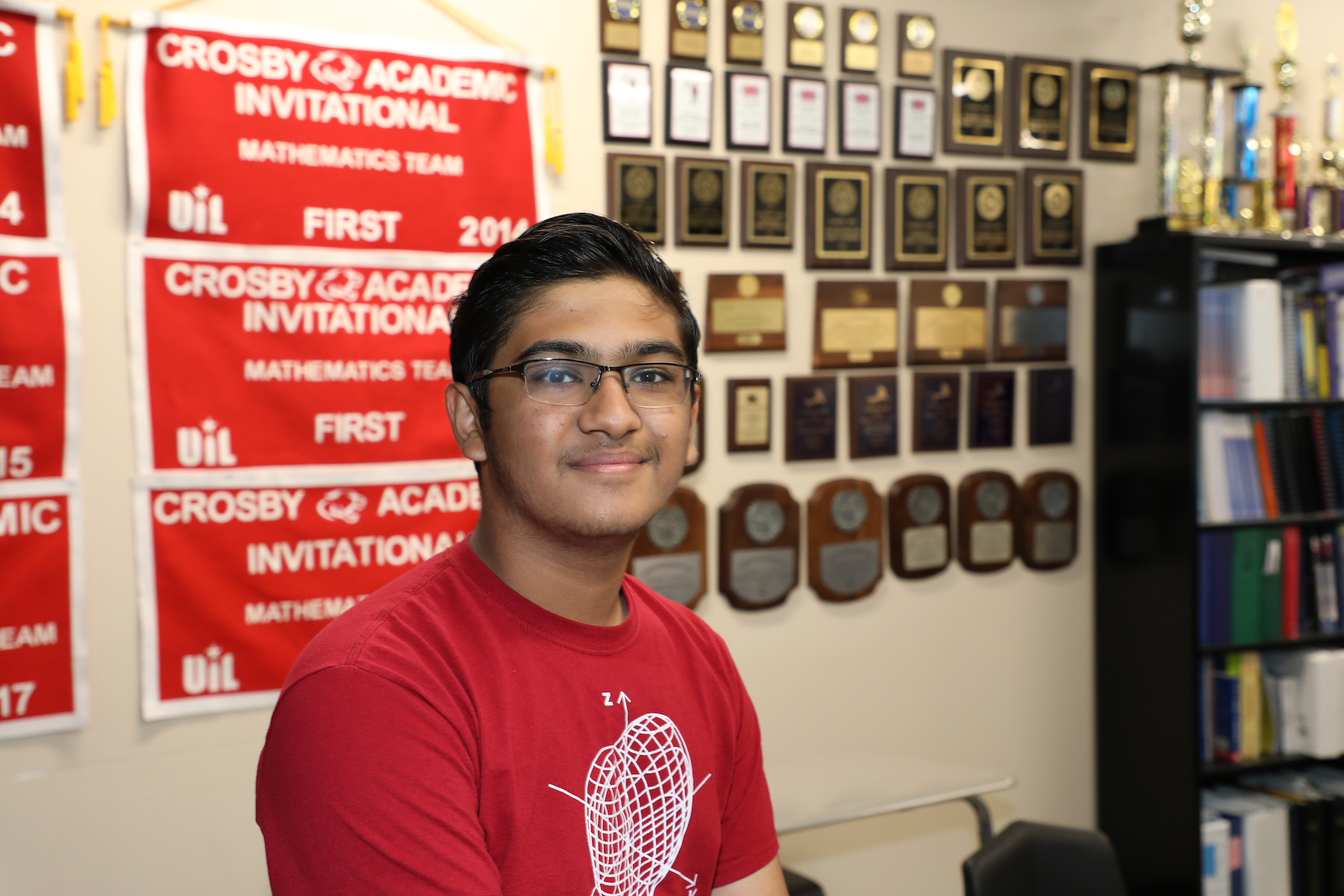 Swayam Gupta poses in front of awards