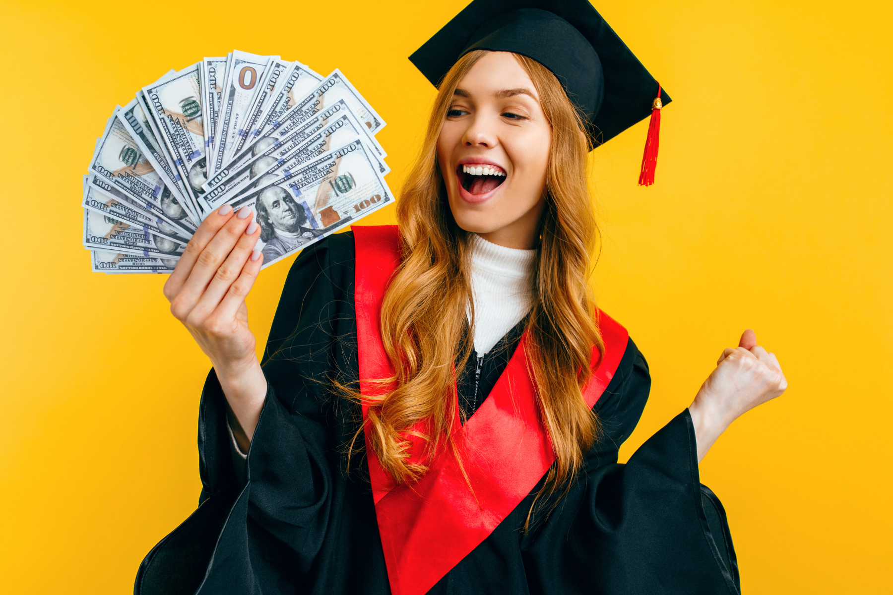 High school student in cap and gown fans out handful of cash