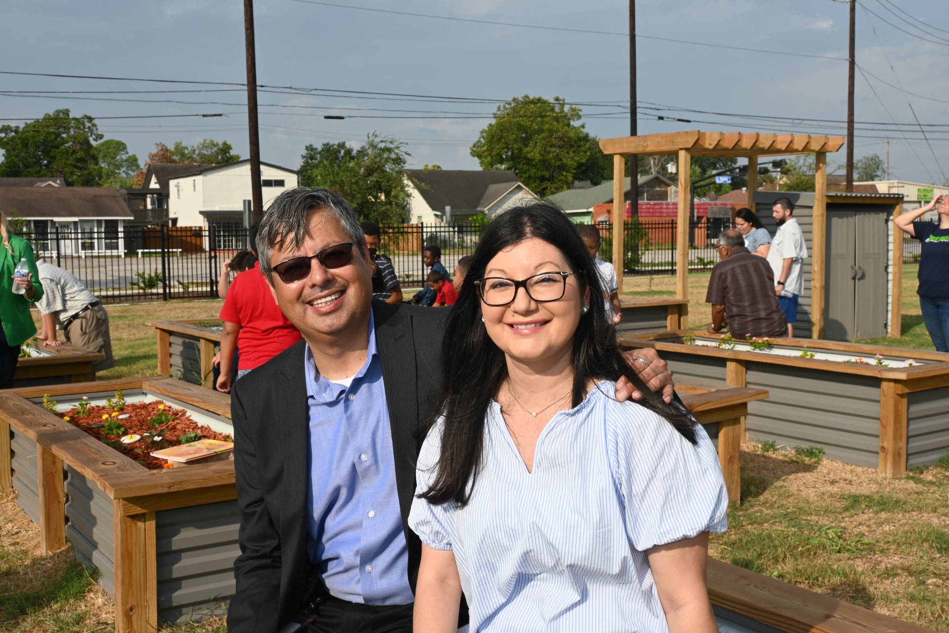 Luis Munoz and sister pose in front of PIE donated garden