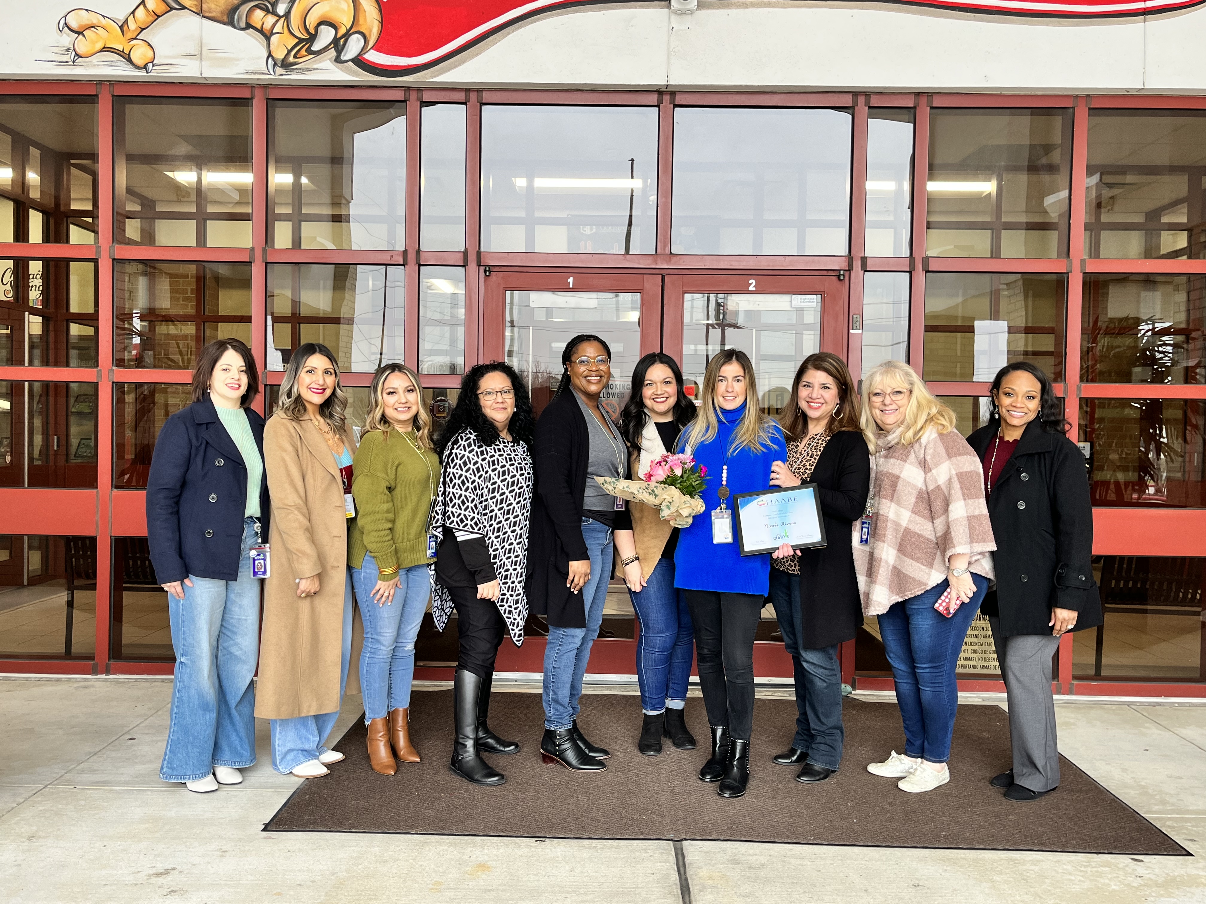harlem elementary bilingual teacher of the year poses in front of the school with admin staff