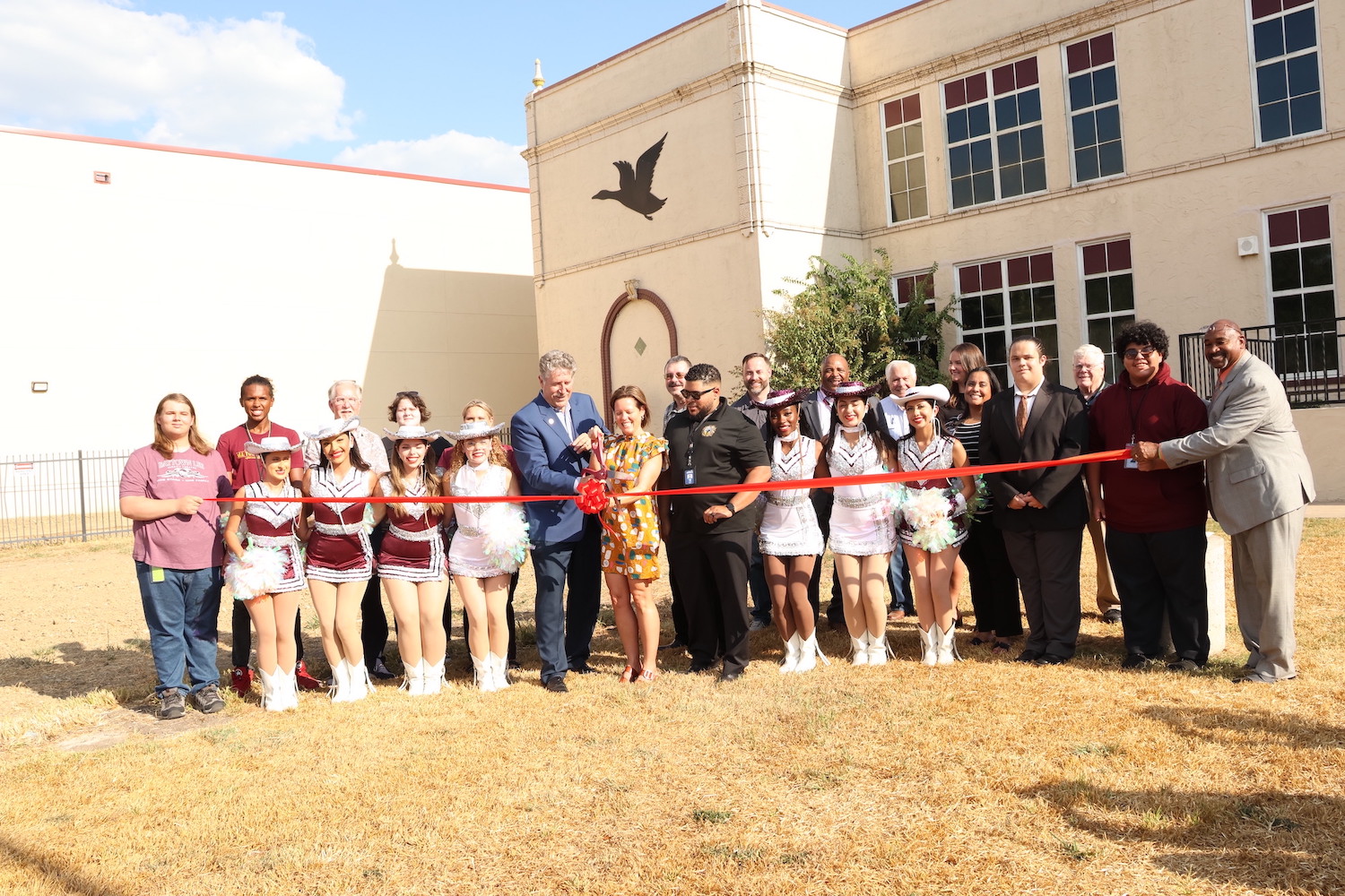 Dr. Randal OBrien and and Tiffany Guy surrounded by other guests, cut the ribbon