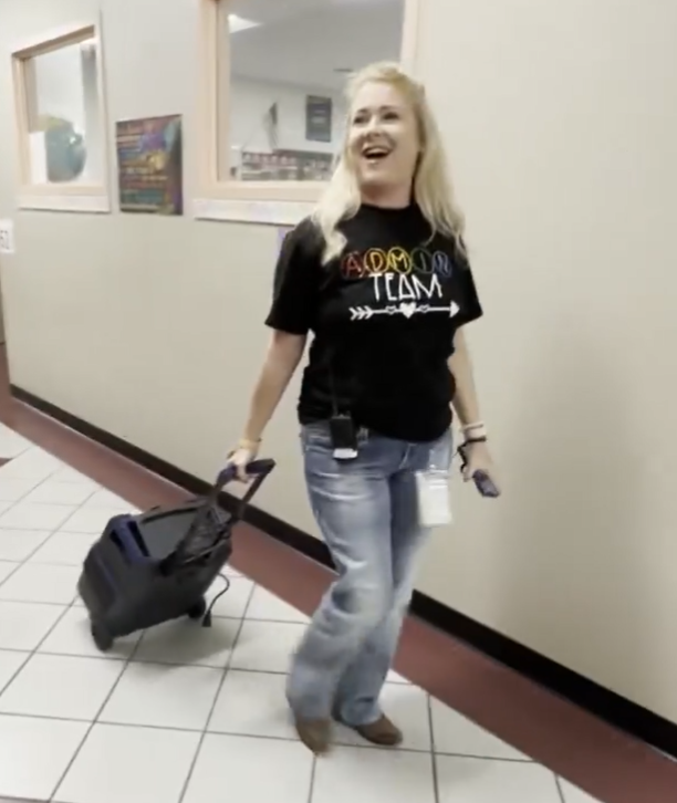 Travis Principal walks the halls of the school dancing with a loud speaker inviting students to join