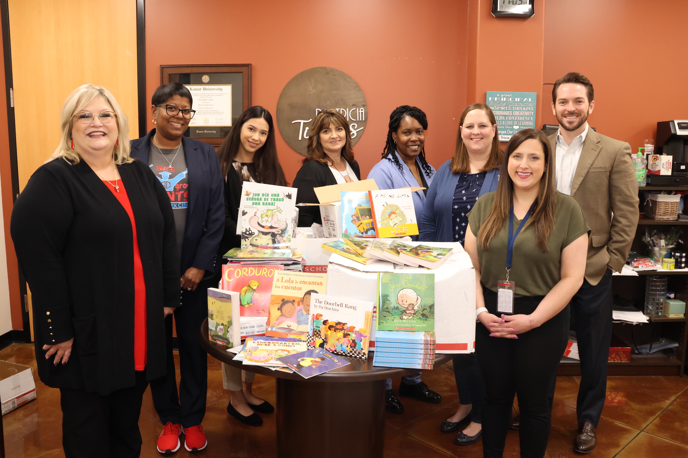 Carlson law firm poses with district administrators and donated books