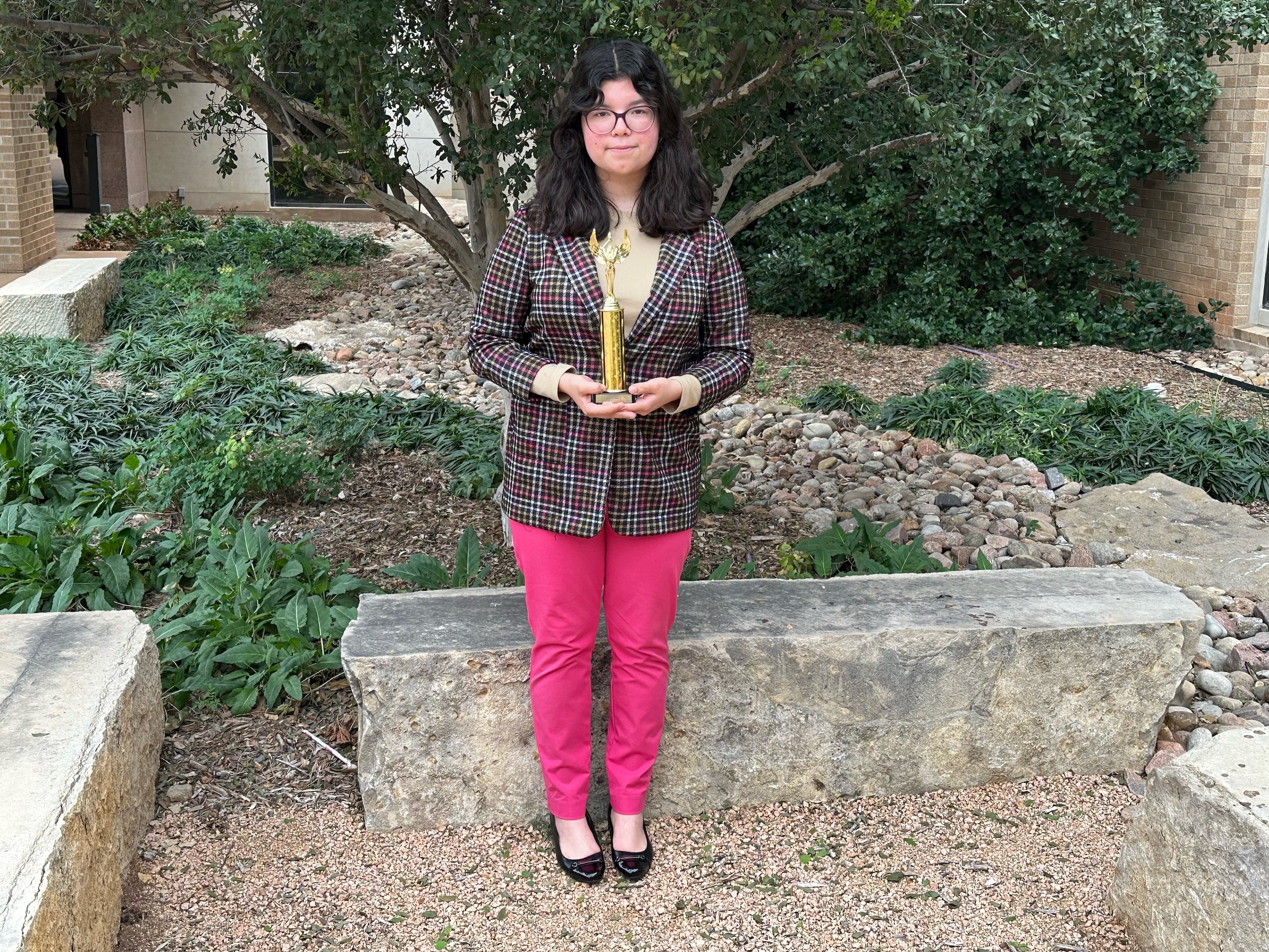 debate team champion poses with trophy