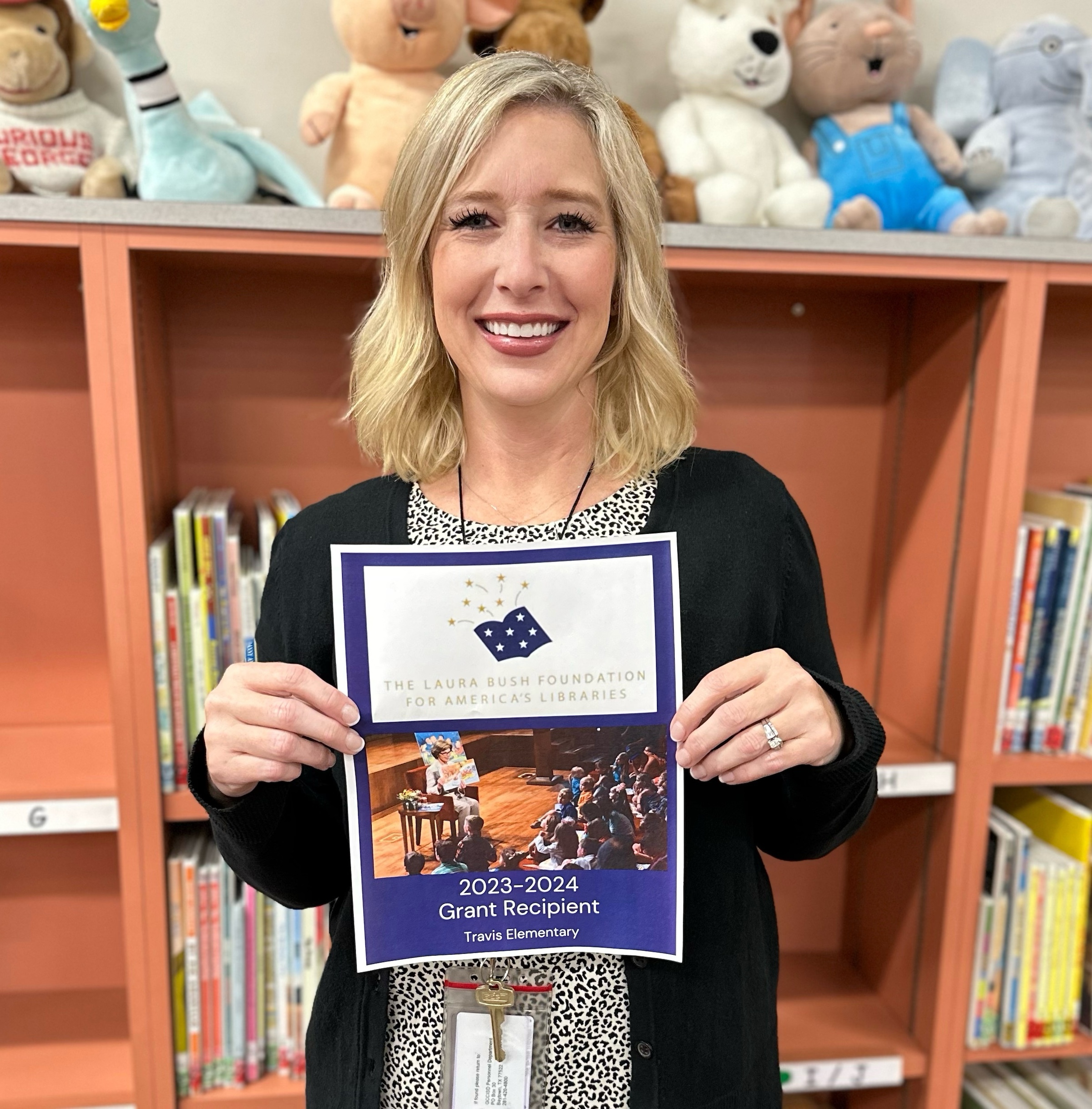 travis librarian poses with grant recipient flyer