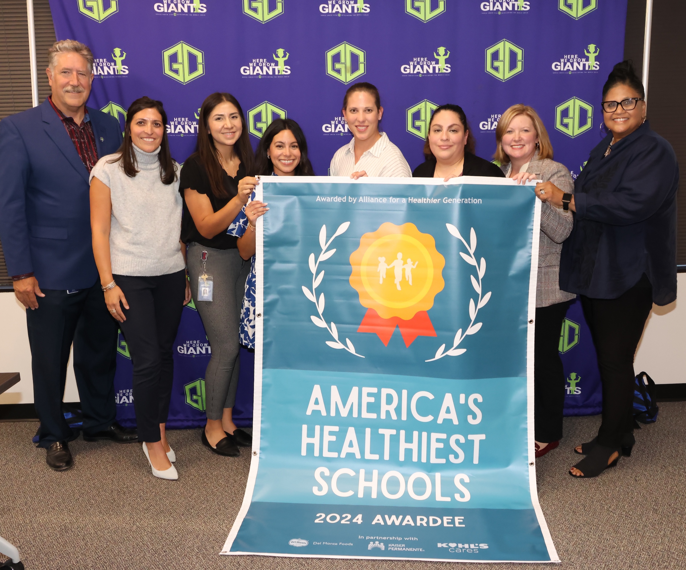 Principals, campus administration, and district administration pose with healthiest schools banner
