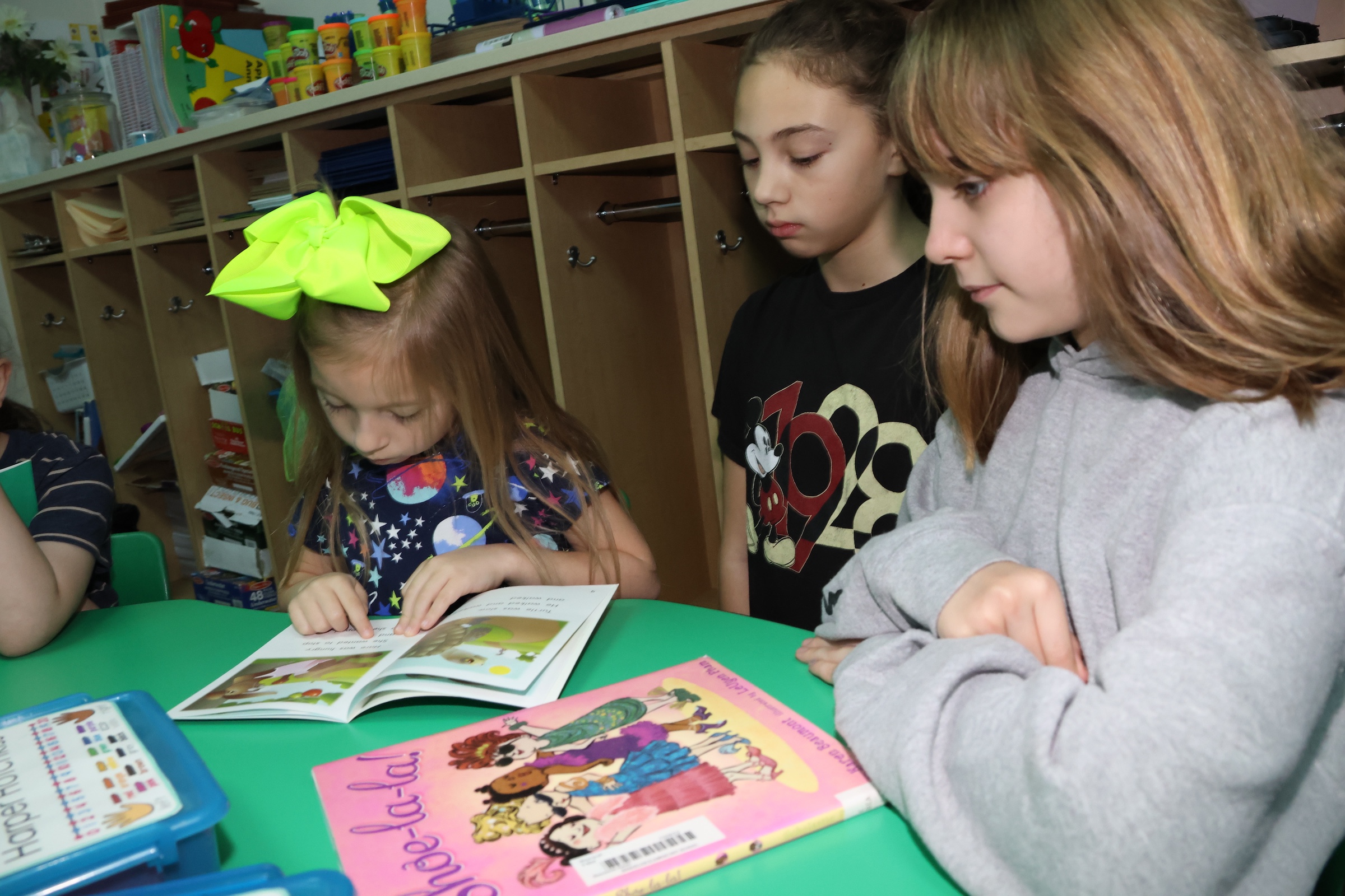 students in kindergarten and fifth grade read to each other
