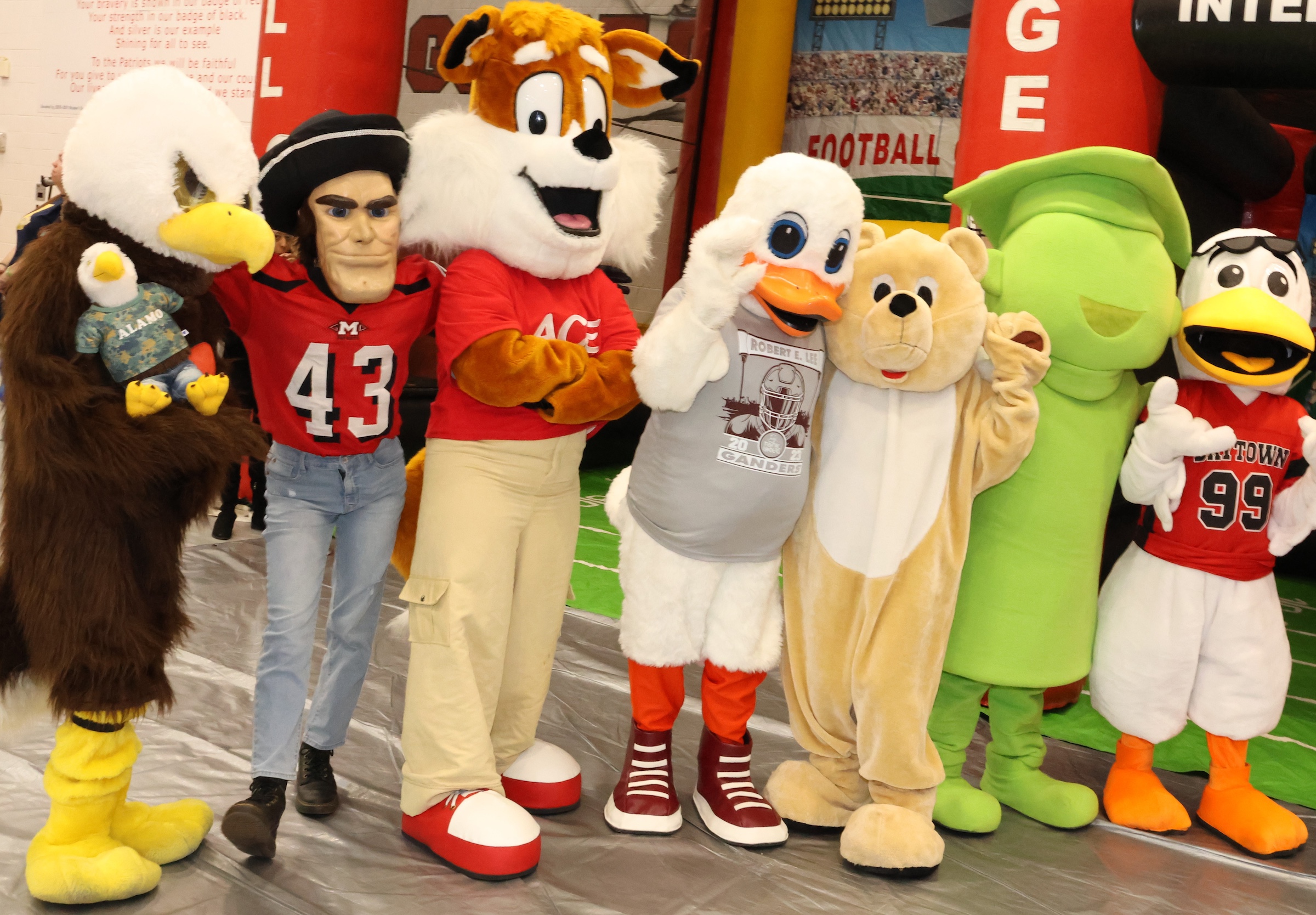 multiple campus mascots pose together with the district giant mascot