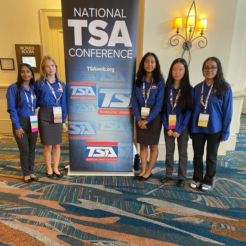 students pose by tsa banner