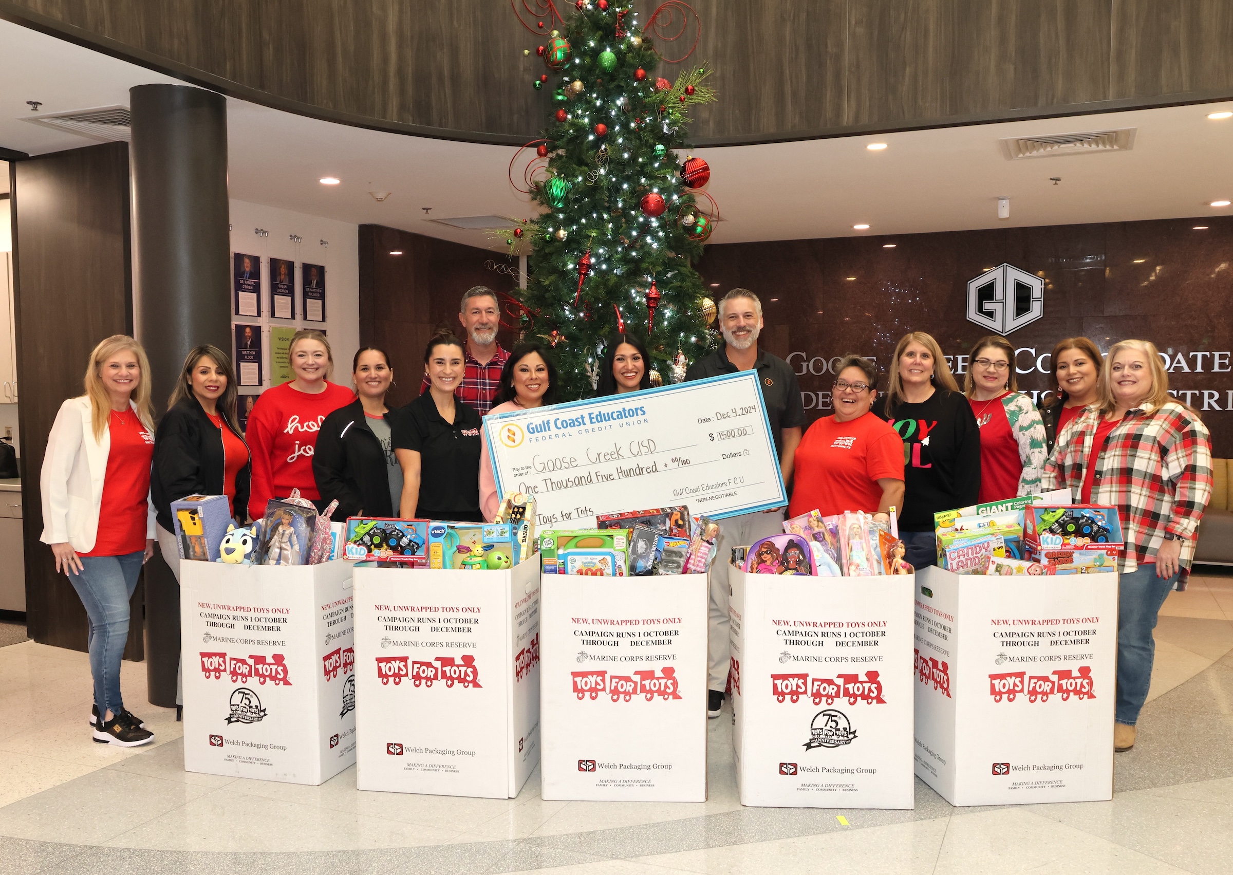 district leaders pose with toys for tots representatives and GCEFCU reps