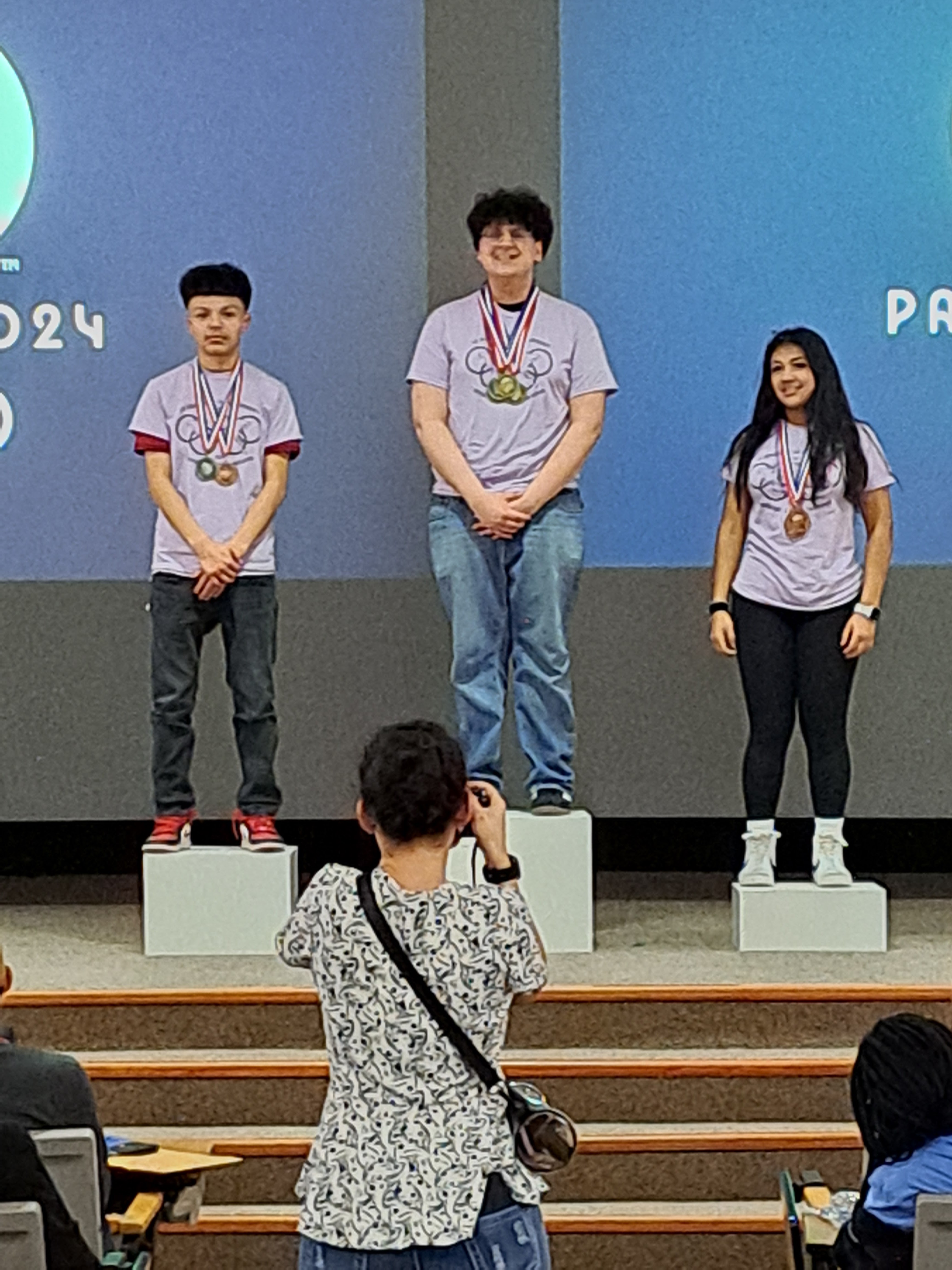 award recipients emerson, axel, and yareni on the podium