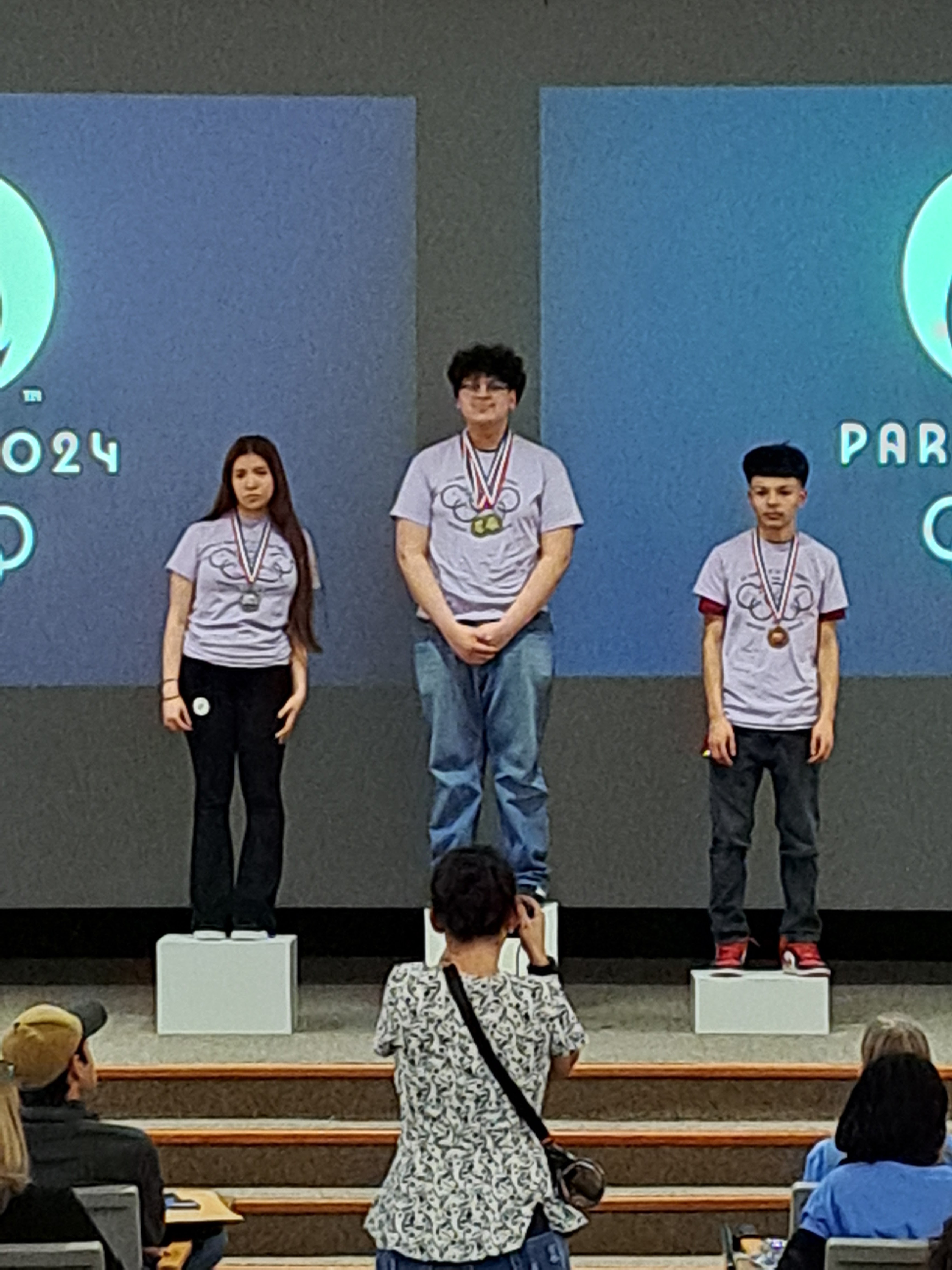 award recipients dina, axel, and emerson on the podium