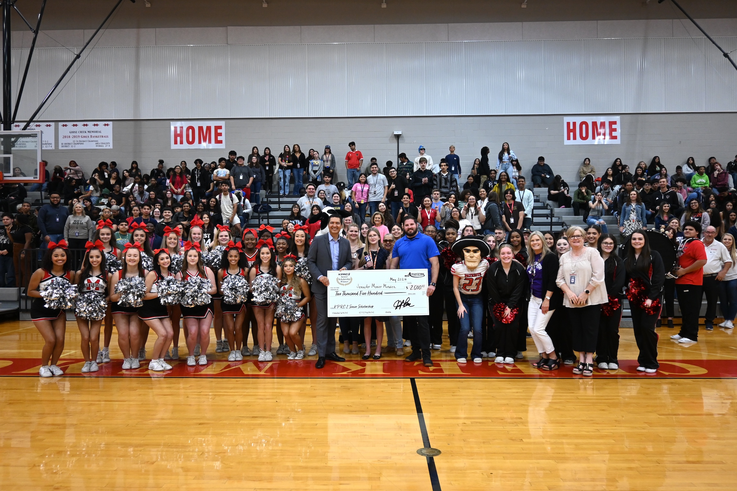 Jenny poses with KPRC, the sponsor, her peers, and campus administrators in the gym