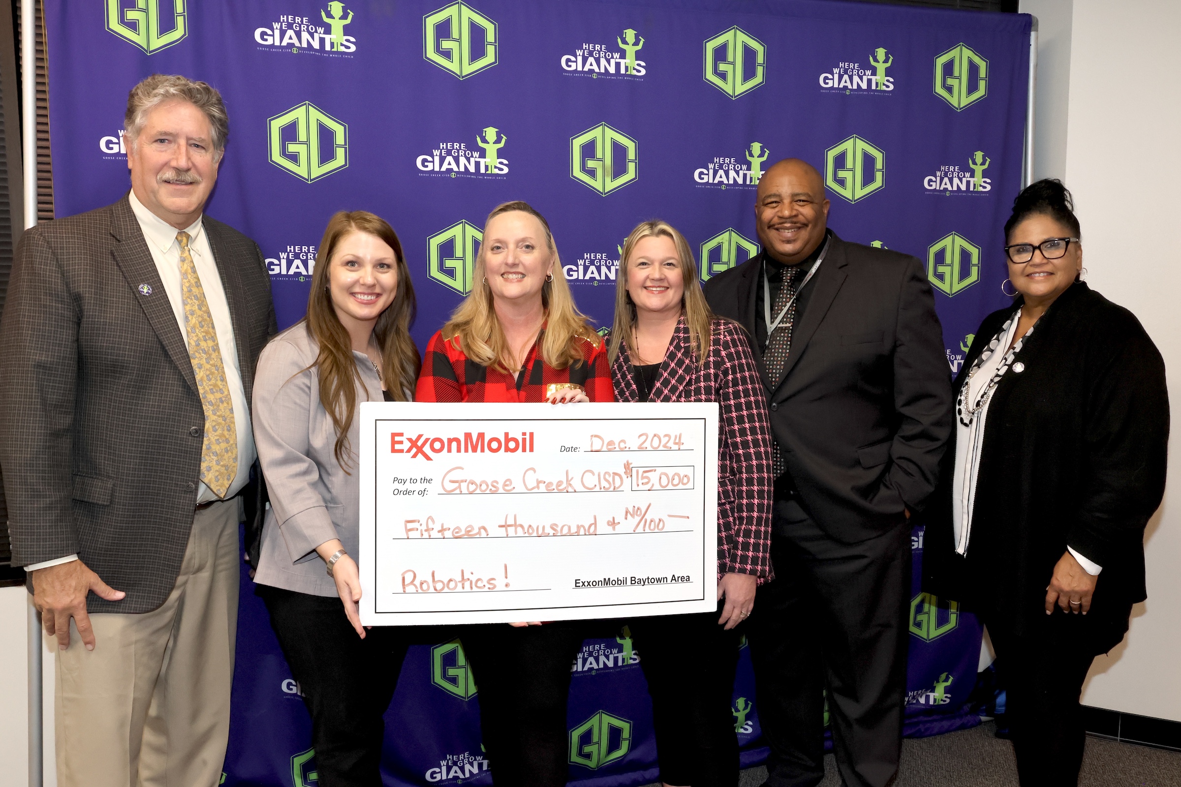 Exxonmobil representatives and district leaders pose with check.