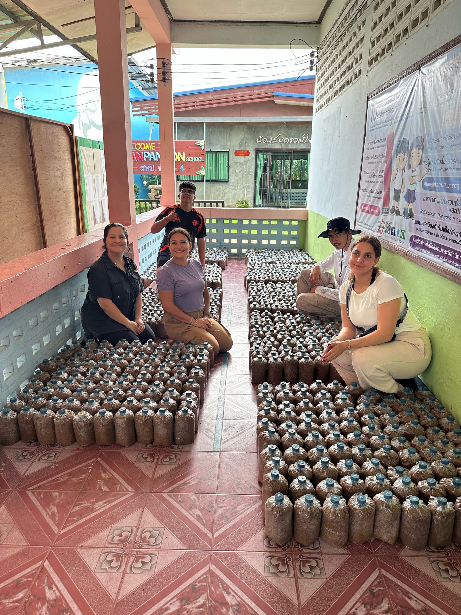 counselor evelyn mexas and impact students pose with mushroom bags bags