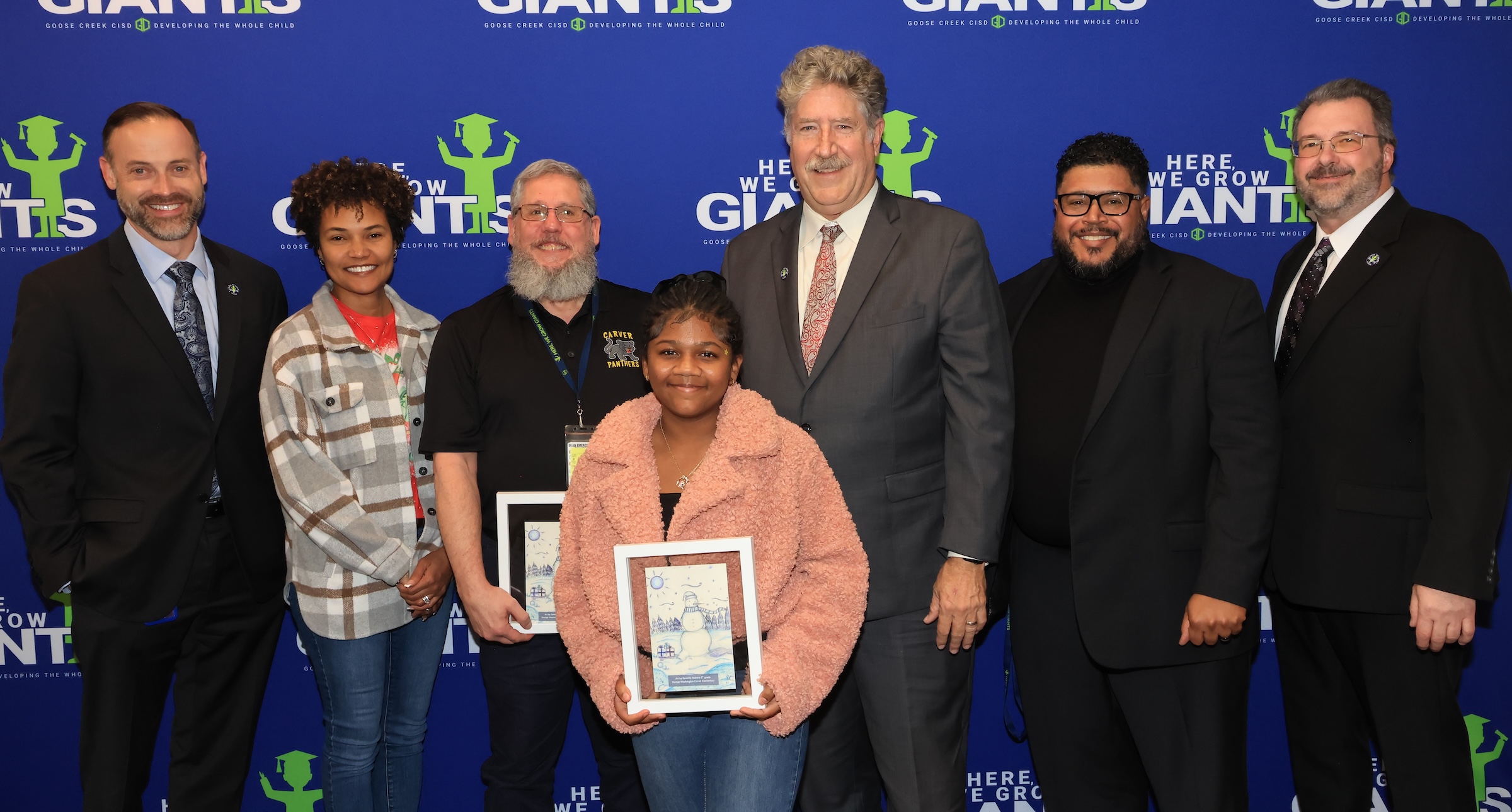district and campus leaders, serenity and her family, and board members pose with card