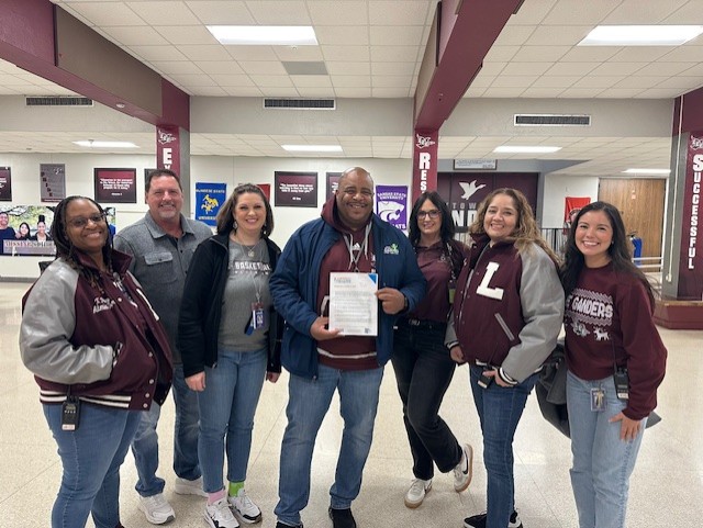 lee high school administrators pose with texas community challenge commitment flyer