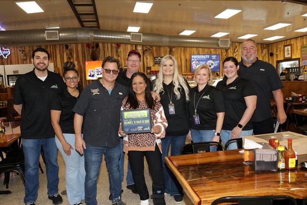 District representatatives pose with Daniels Meat Market reps with their CTE award inside the market
