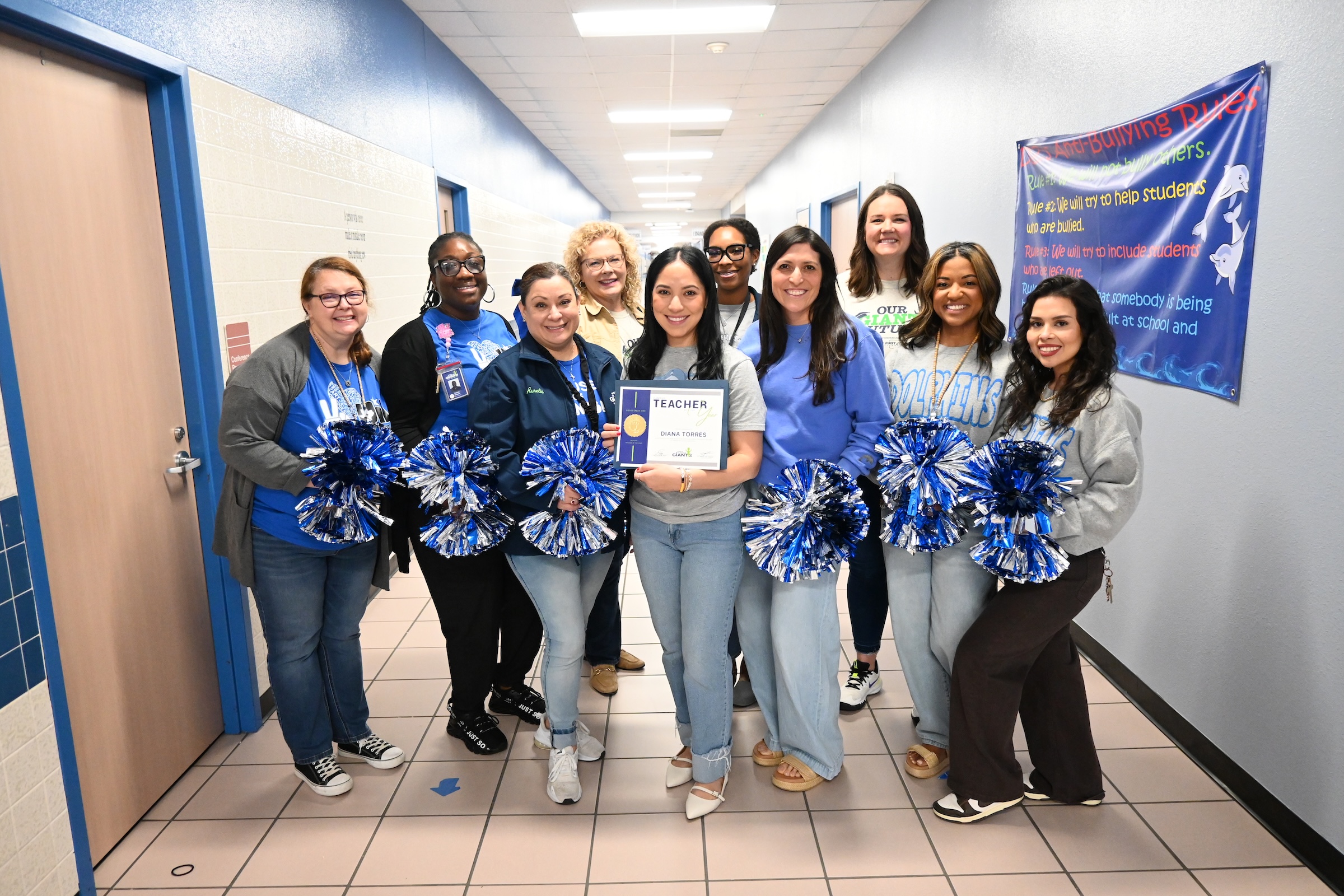 De Zavala staff and district leaders pose with the campus teacher of the year and her award