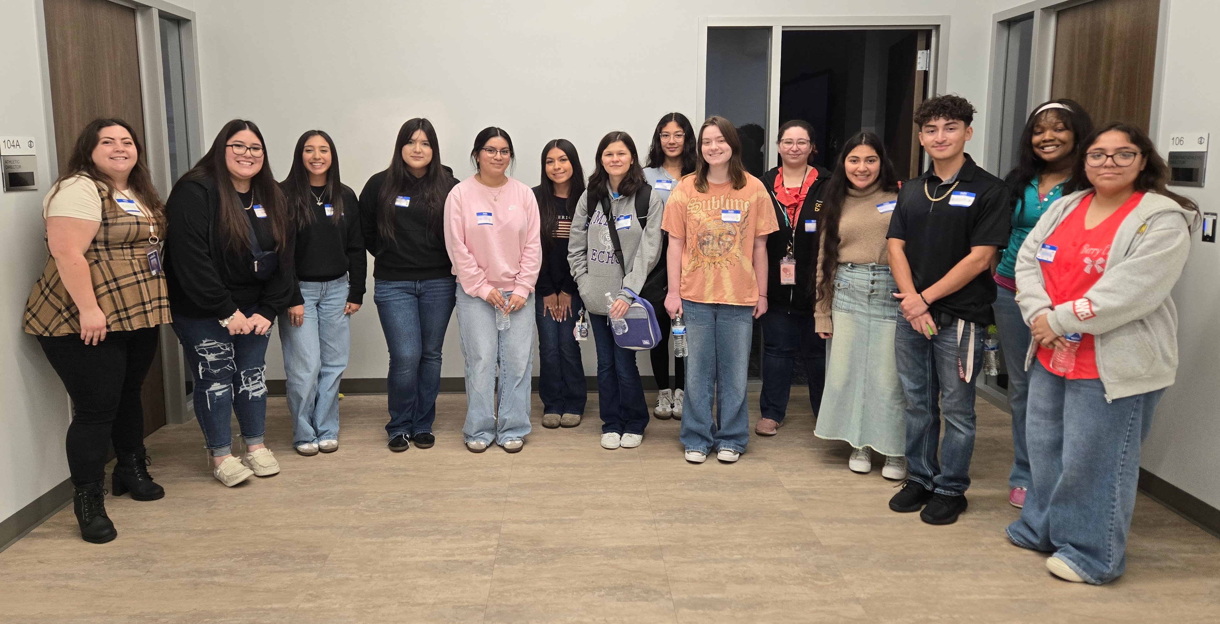 Giants care collective student members pose in room for photo with coordinator of marketing