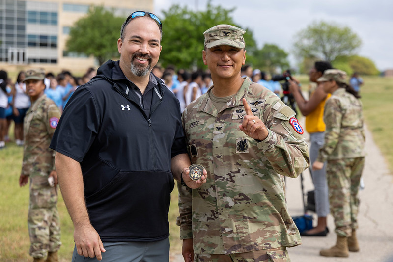 Coach Garson standing with senior army leadership representative in front of a building