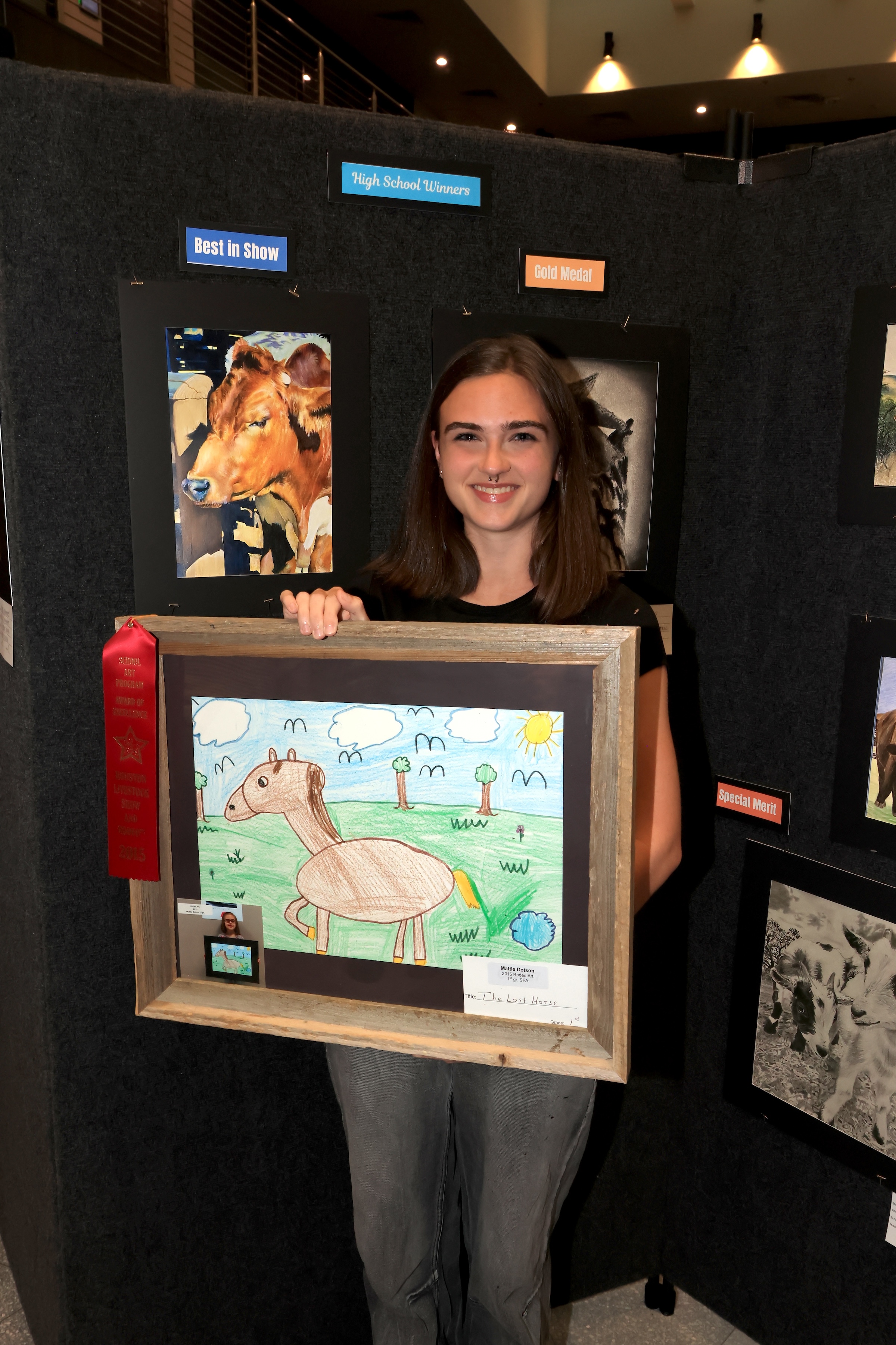 student holds rodeo artwork