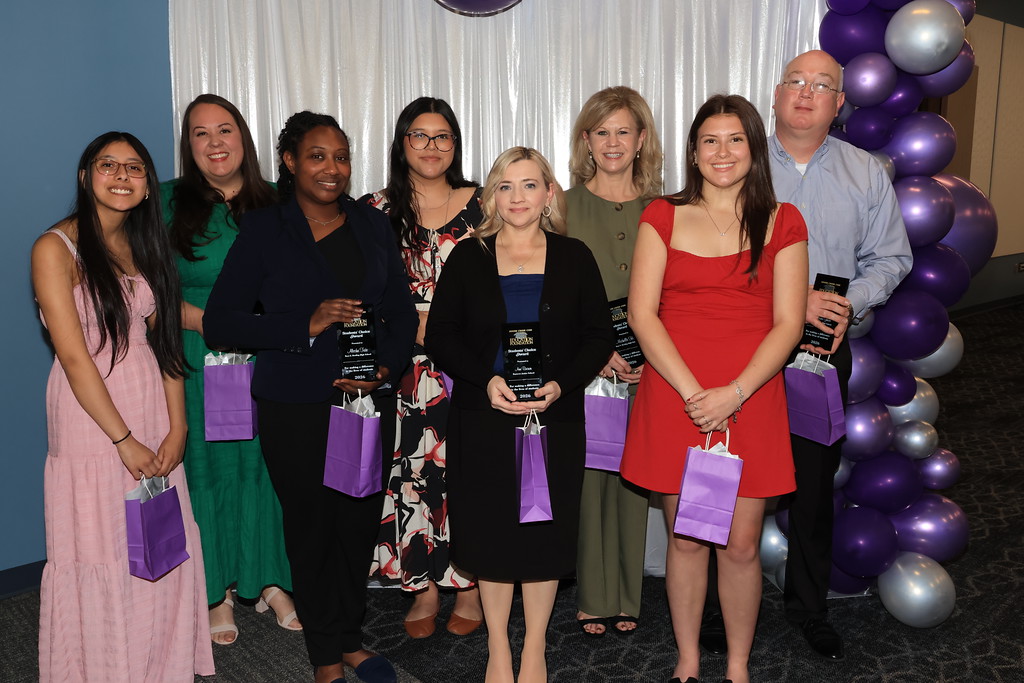 teachers being honored and students who nominated them stand in front of a photo wall