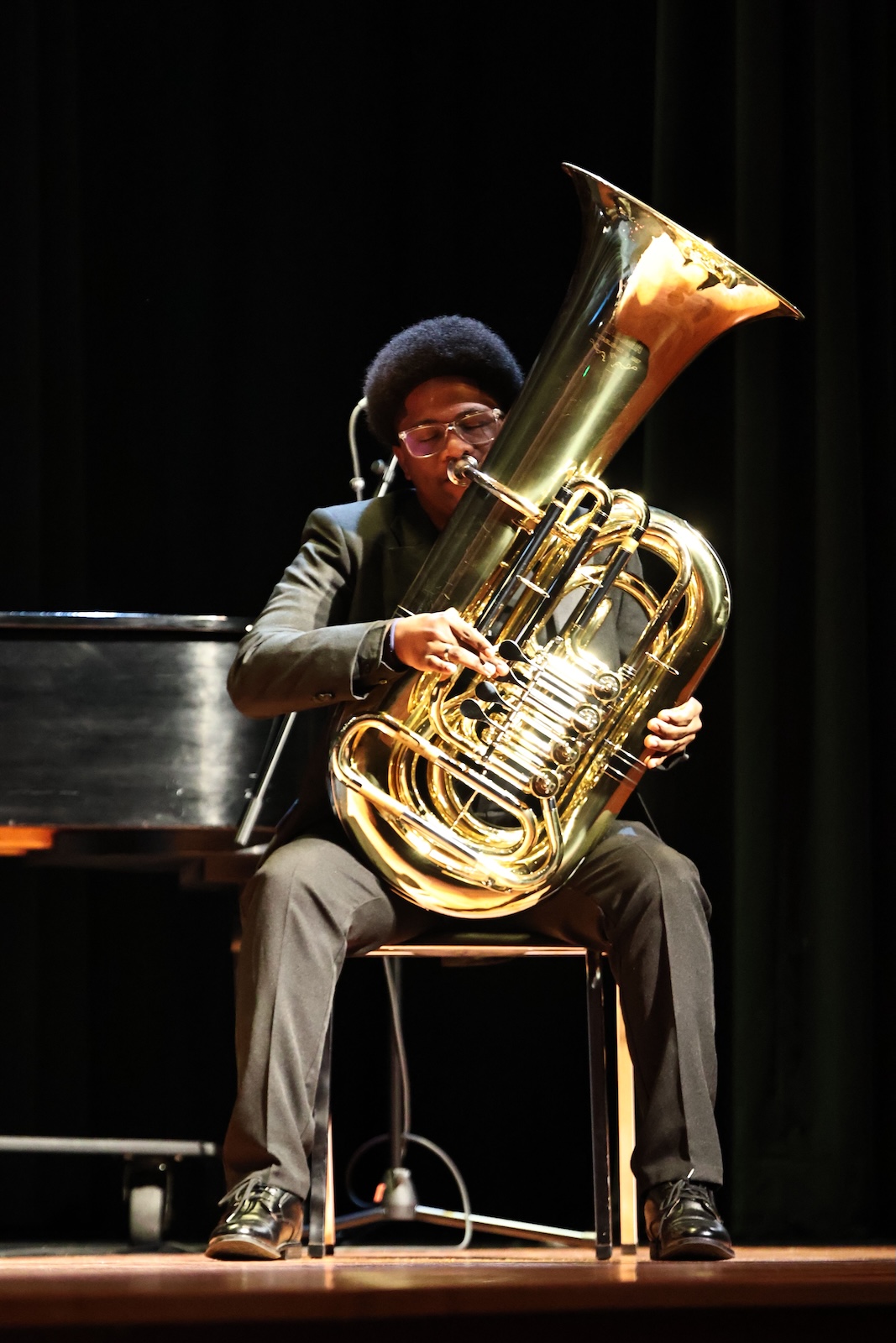 Seth lewis playing his instrument on stage in a black suit