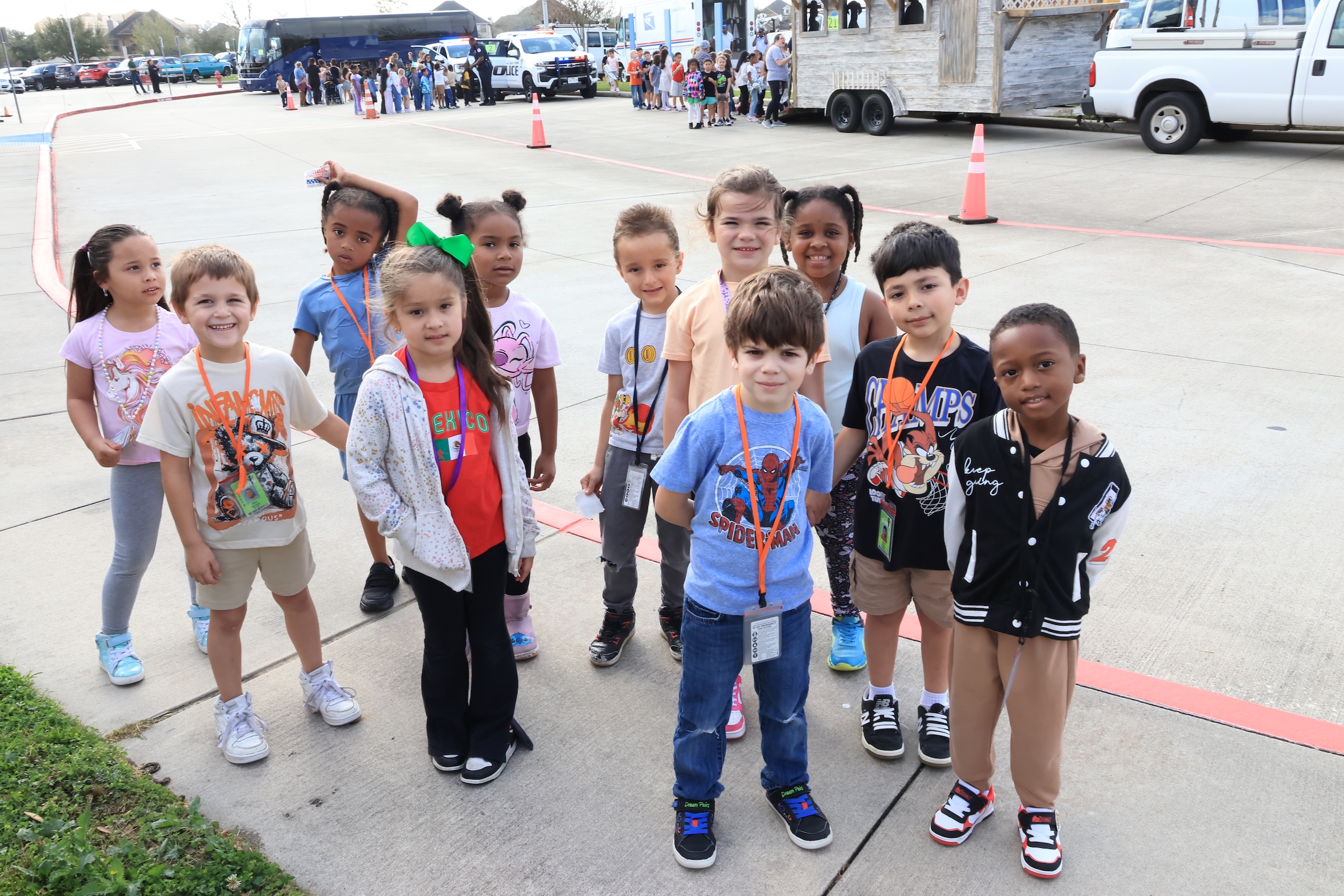 students stand on sidewalk in front of careers on wheels vehicles