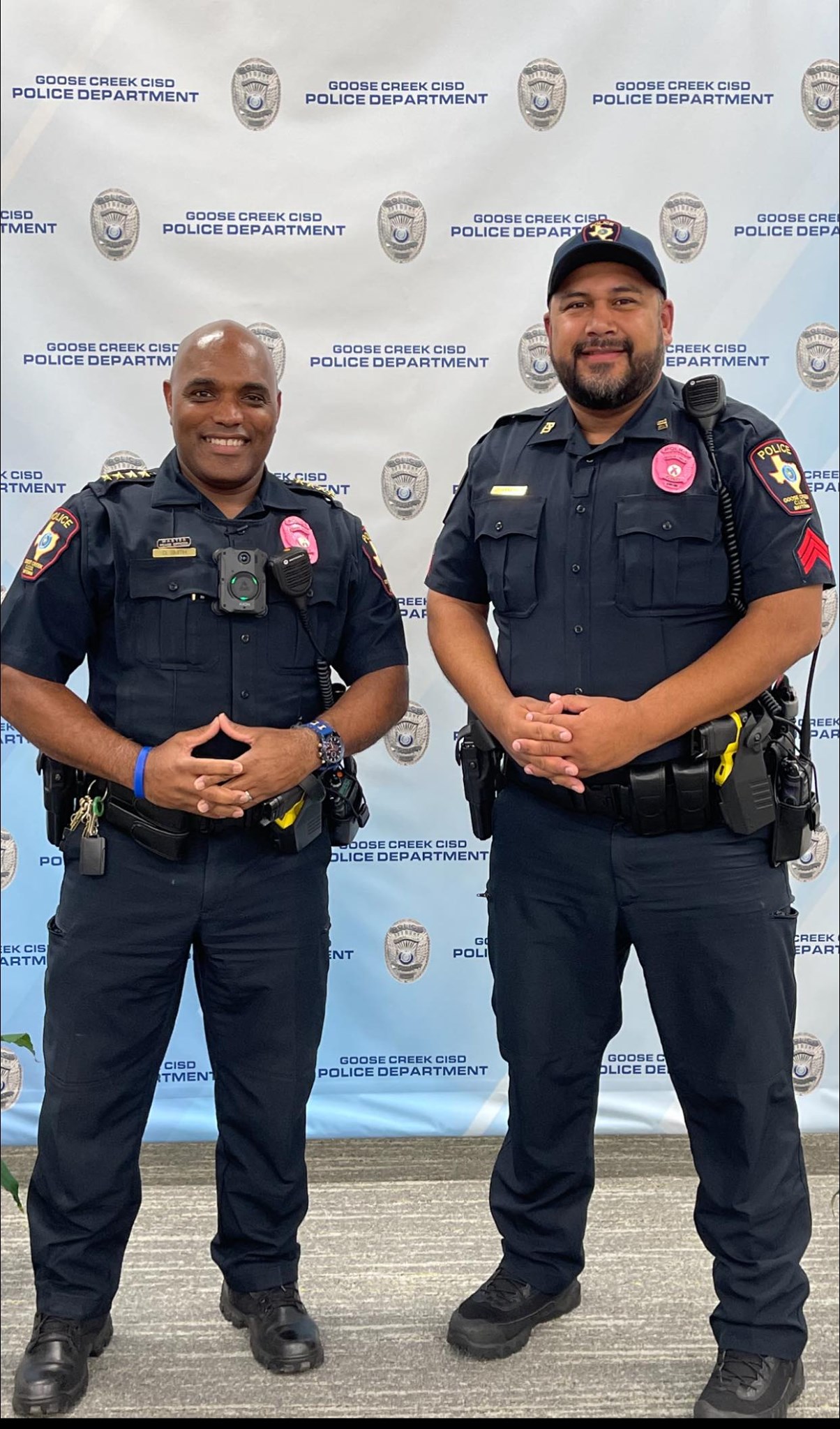 chief and police officer wear pink badges in honor of breast cancer awareness month.